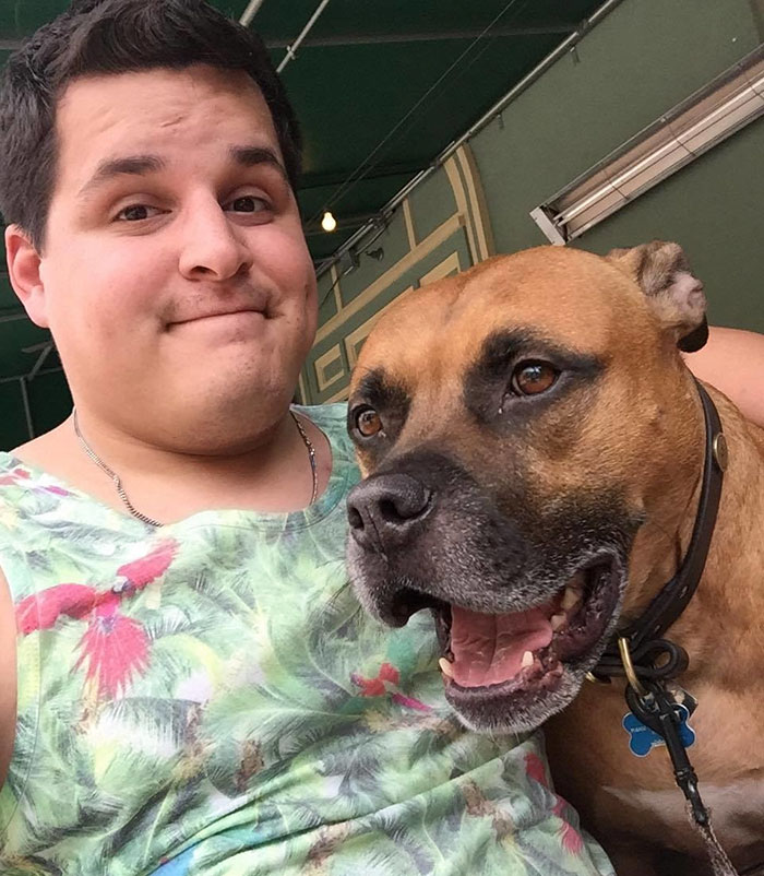 Man with his rescue dog, both featuring matching neutered dog tattoo, smiling together outdoors. Man with his rescue dog, both featuring matching neutered dog tattoo, smiling together outdoors.