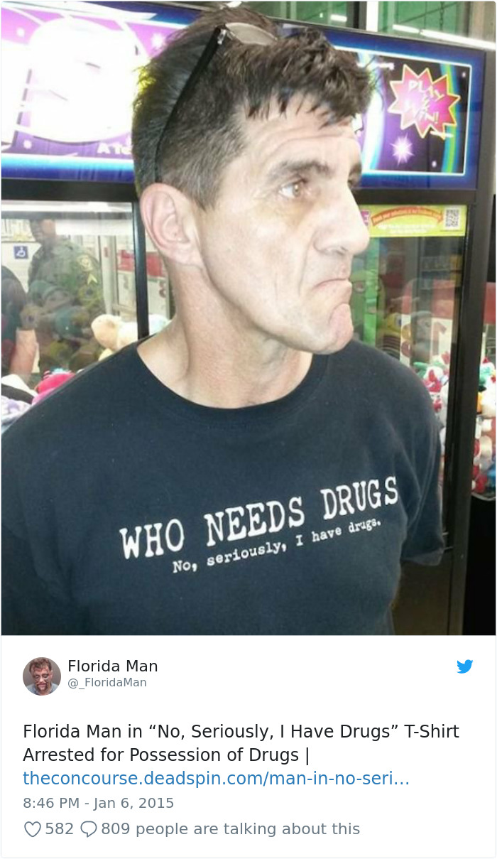 Florida man with "Who Needs D***s" shirt arrested, standing indoors with sunglasses on his head.