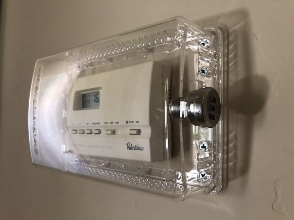 Thermostat locked in a clear case with a combination lock, showcasing a dad's humorous solution.