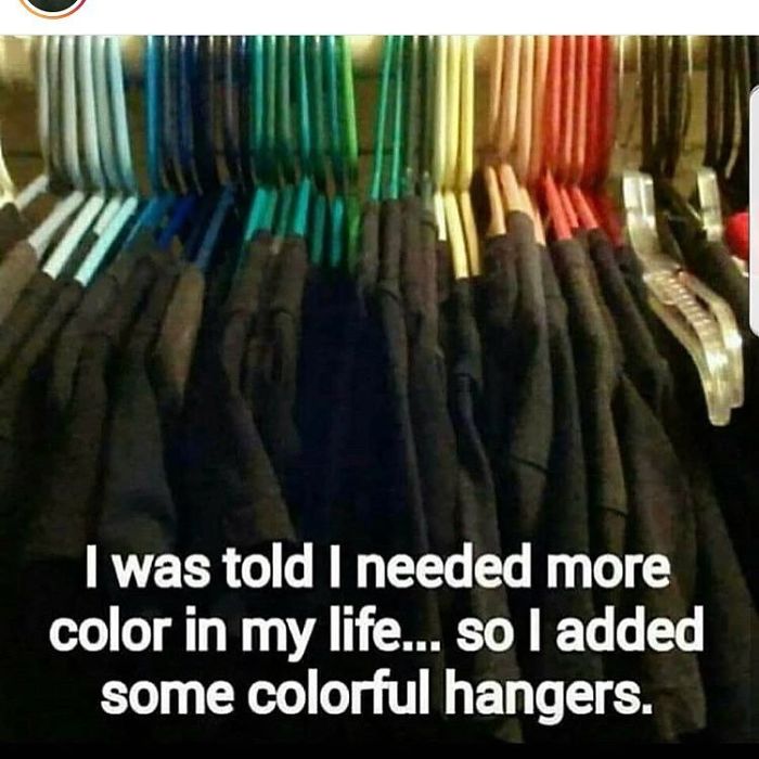 Colorful hangers among dark clothes with humorous meme text about life advice from a hairstylist.