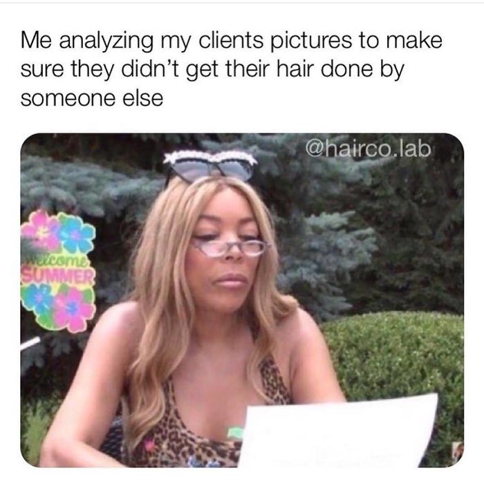 A woman in sunglasses analyzing a photo, humorously questioning a client's hairstyling choice.