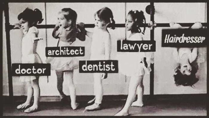 Kids lined up with career labels, one upside down as "Hairdresser", humorously highlighting hairstylist challenges.