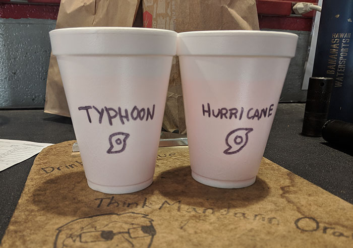 Two foam cups labeled Typhoon and Hurricane, humorously referencing Asian and white stereotypes by coworkers.