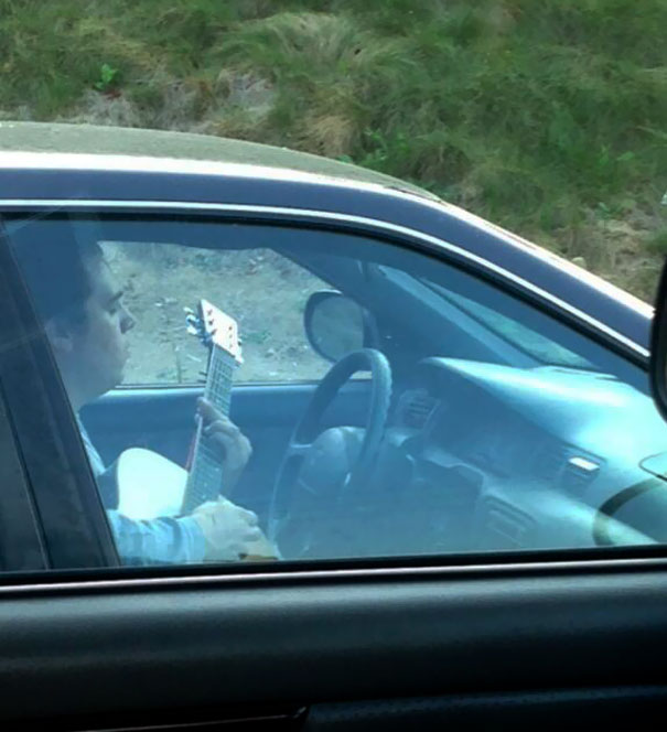 This Guy Is Playing His Guitar While He's Driving