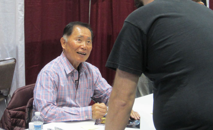 George Takei sitting and looking