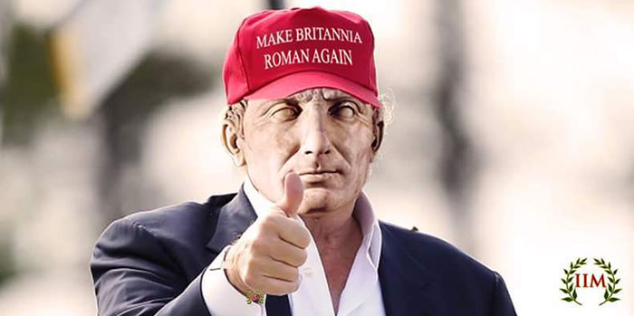 Bust of ancient Roman figure wearing a red Make Britannia Roman Again hat and giving a thumbs-up gesture.