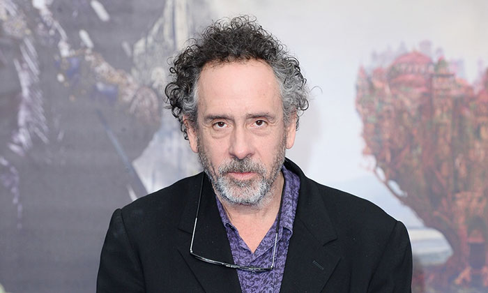 Tim Burton wearing black suit and looking