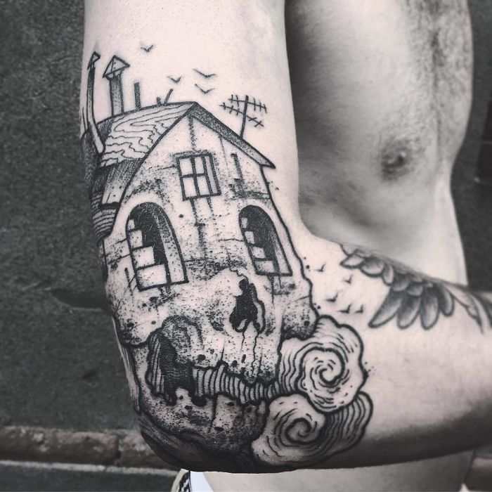 Tattoo of a house design on an arm, revealing its genius artistry when the arm is extended. Tattoo of a house design on an arm, revealing its genius artistry when the arm is extended.