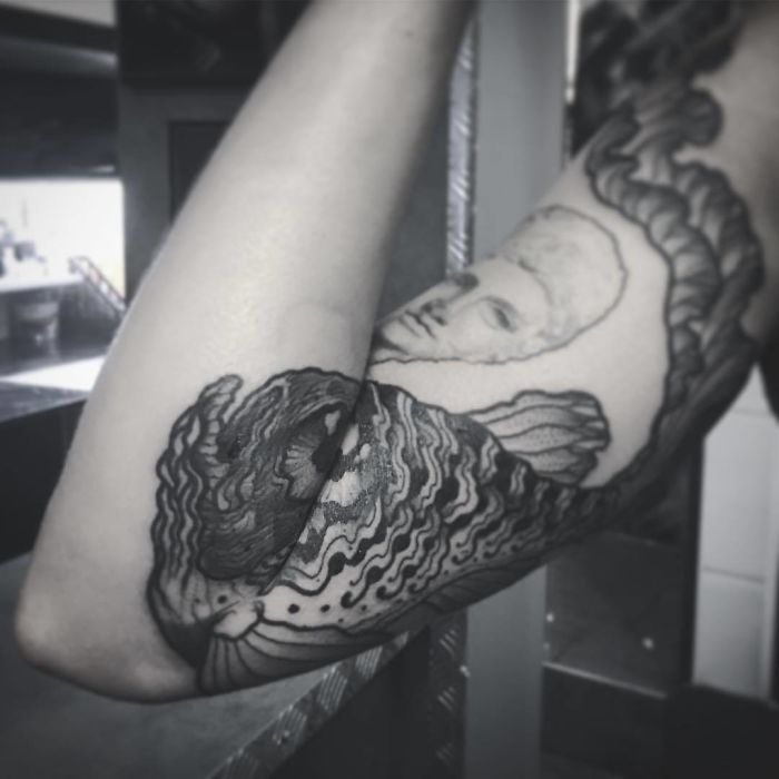 Tattoo design unfolds on arm, revealing intricate artwork when extended. Tattoo design unfolds on arm, revealing intricate artwork when extended.