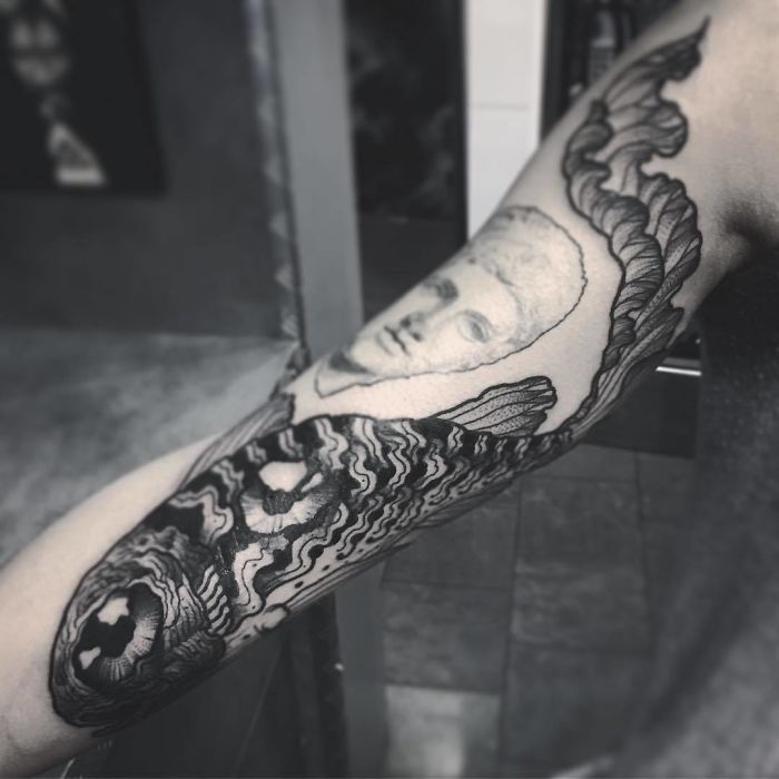 Artistic tattoo on an arm, reveals a detailed design with flowing lines when extended. Artistic tattoo on an arm, reveals a detailed design with flowing lines when extended.