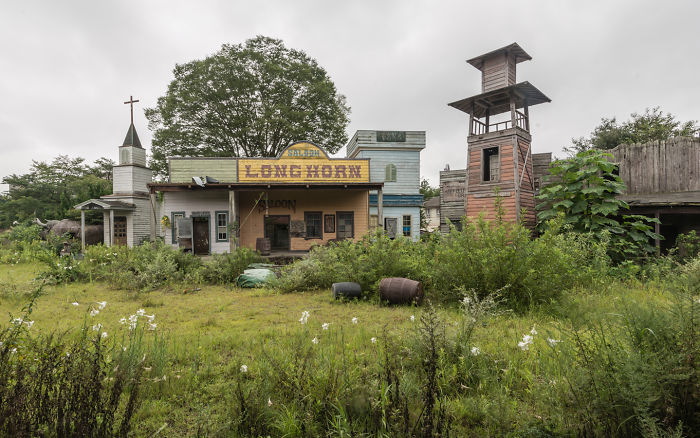 Abandoned western-style buildings overgrown with vegetation in a forgotten area while traveling around Japan.