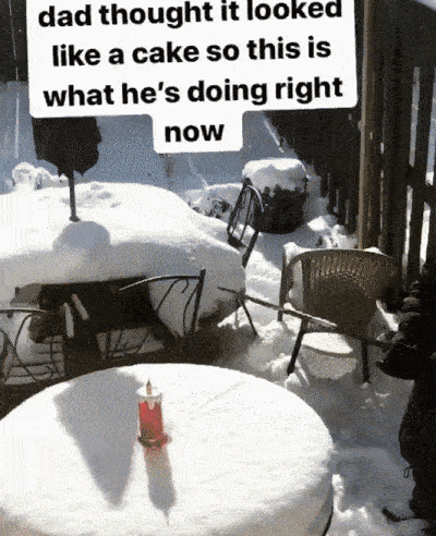 Dad humorously pretends to cut a snowy table resembling a cake on a winter patio.