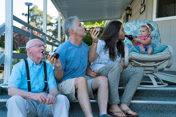 Four generations humorously mimicking drinking, with funny dads and baby on porch steps.