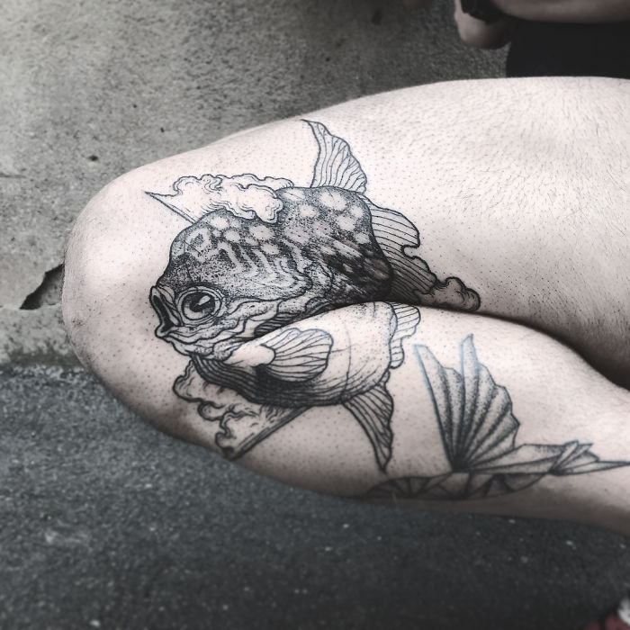 Tattoo of a fish on a bent knee, revealing full design when leg is extended. Tattoo of a fish on a bent knee, revealing full design when leg is extended.