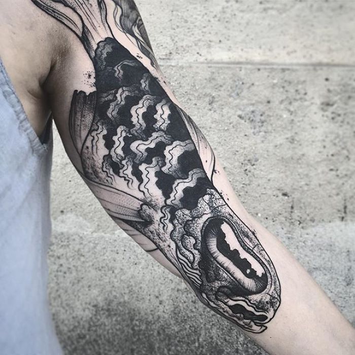 Unique arm tattoo in black ink, revealing detailed design when extended, showcasing tattoo artistry. Unique arm tattoo in black ink, revealing detailed design when extended, showcasing tattoo artistry.