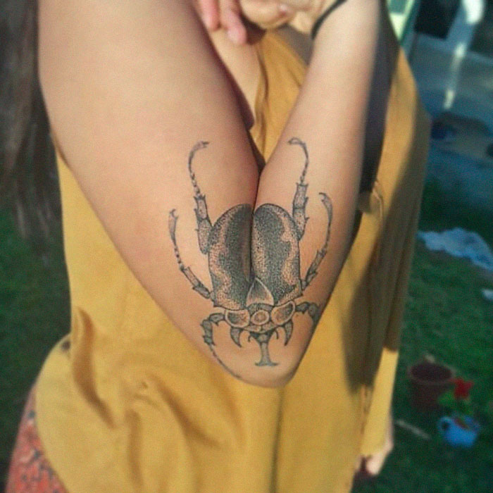 Arm with a detailed beetle tattoo, revealed by extending the elbow. Arm with a detailed beetle tattoo, revealed by extending the elbow.