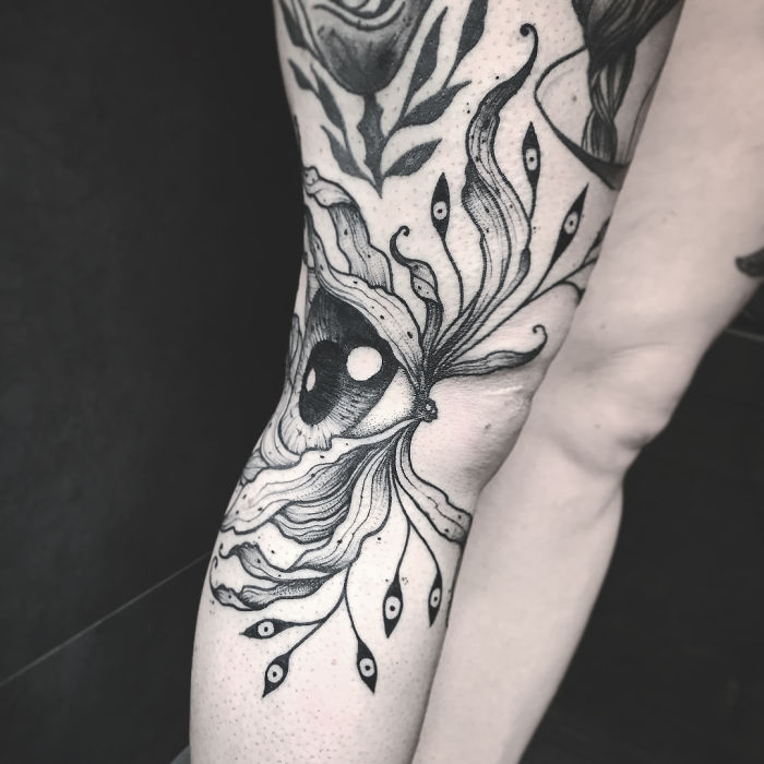 Tattoo art on arm revealing an eye design, visible when the arm is extended, showcasing its intricate beauty. Tattoo art on arm revealing an eye design, visible when the arm is extended, showcasing its intricate beauty.