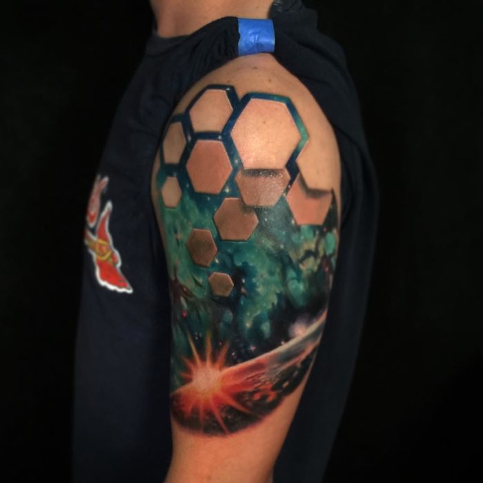 3D tattoo of a cosmic scene with hexagonal pattern on arm, creating a stunning optical illusion.