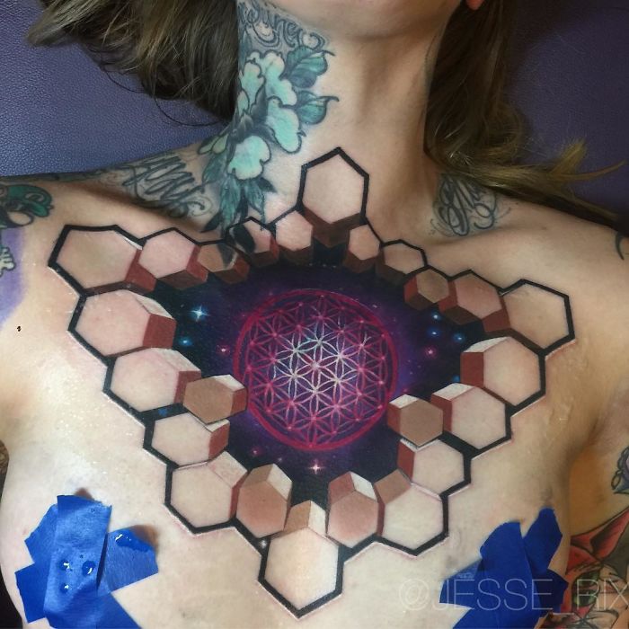 3D tattoo of geometric shapes and cosmic design on chest, showcasing intricate details and depth illusion.
