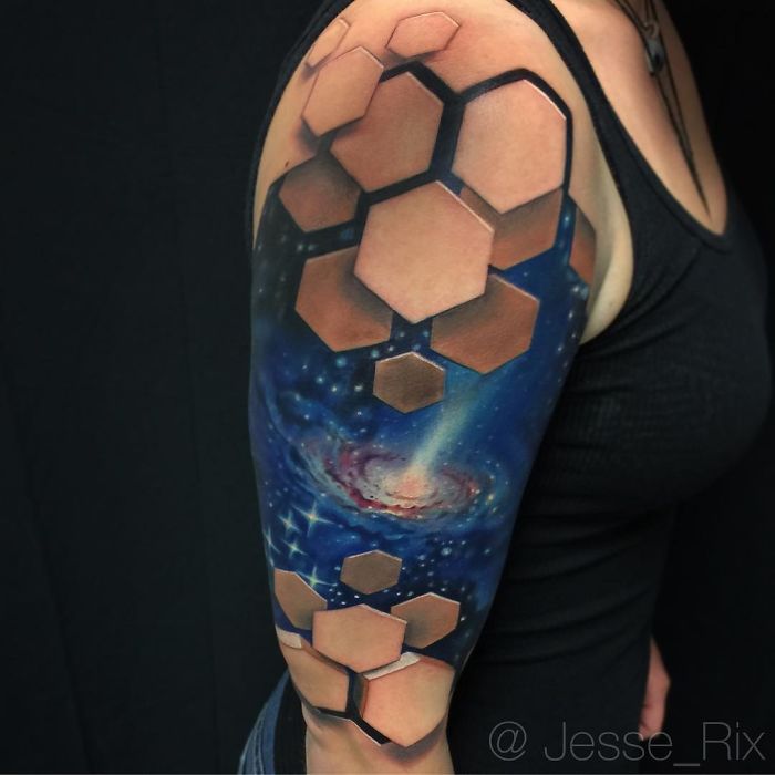 3D tattoo of a galaxy with hexagon pattern on an arm, creating a stunning optical illusion.