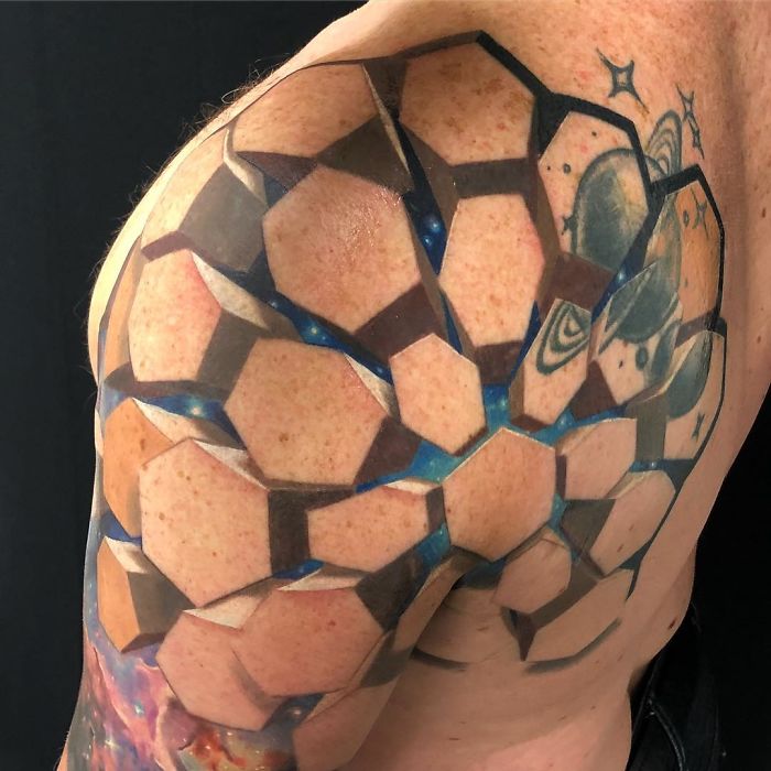 3D tattoo art on a shoulder, featuring geometric shapes and illusion of depth, showcasing amazing tattoo design skills.