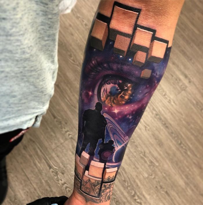 3D tattoo of a cosmic scene with an eye, silhouettes, and geometric shapes on a forearm.