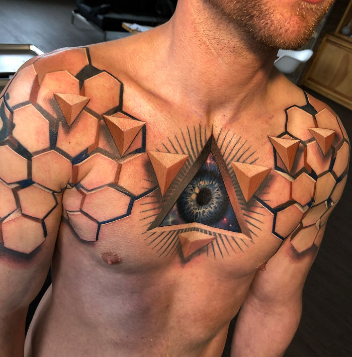 3D tattoo on chest featuring geometric patterns and an eye, creating a stunning illusion.