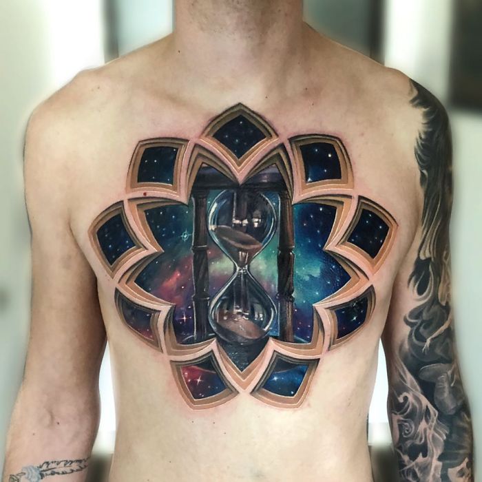 3D tattoo of a cosmic hourglass on a man's chest, creating a striking optical illusion.