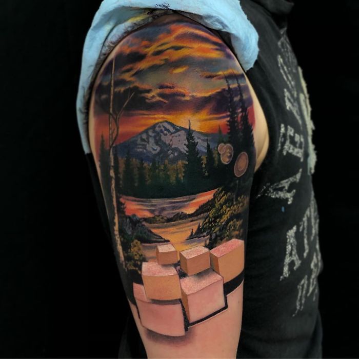 3D tattoo of a landscape incorporating cubes and a mountain scene on an arm, showcasing amazing artistry and detail.