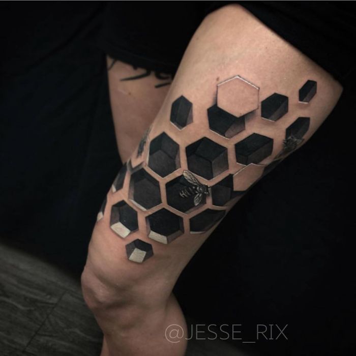 3D tattoo with hexagonal pattern and bee design on a person's arm.