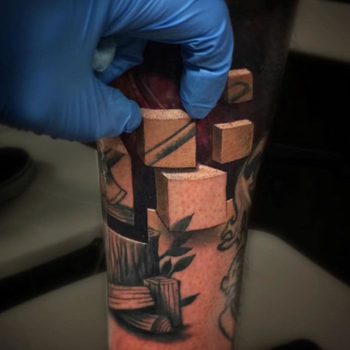 3D tattoo of geometric shapes on an arm with a gloved hand, showcasing amazing depth and realism.