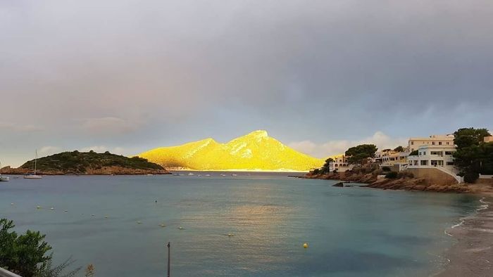A Small Gap In The Clouds Allowed The Sun To Catch A Small Island Off The Coast During A Stormy Day In Mallorca, Spain