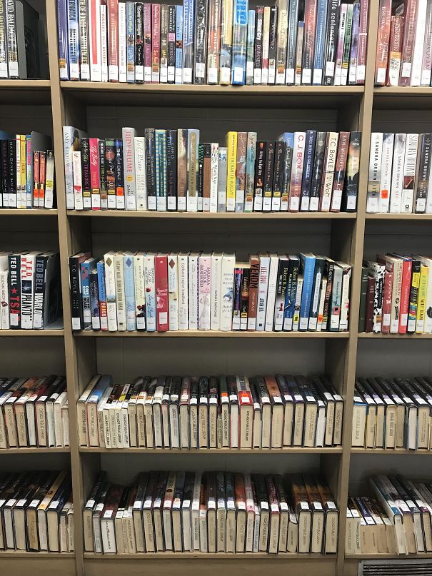 The Library Places The Books On The Lower Shelves On Their Sides So The Titles Are Easier To Read