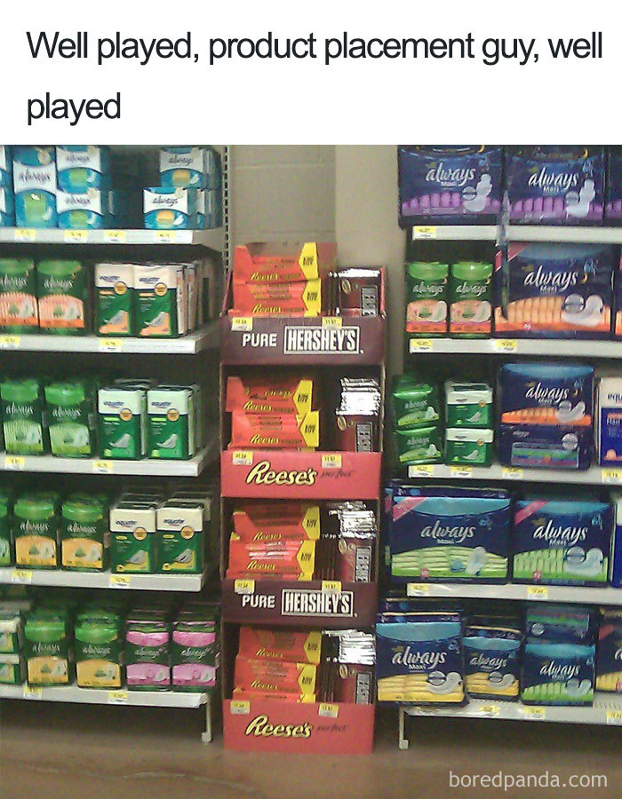 Tampon and pad aisle with Reese's and Hershey's chocolate display, humorously highlighting product placement.