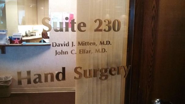 Hand surgery clinic door with doctors' names listed, viewed from the lobby area.