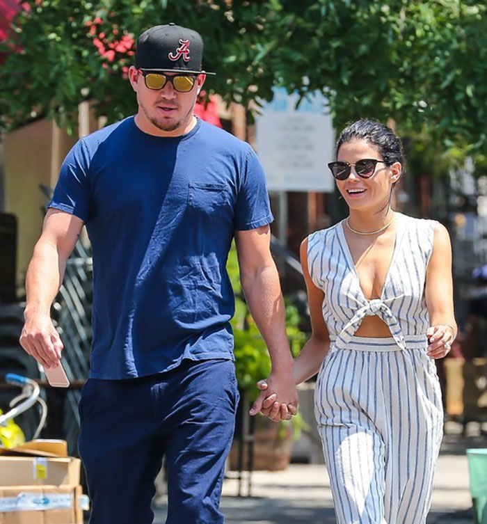 Couple holding hands and smiling outdoors, representing celebrities who fell in love while acting together.