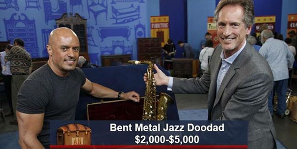 Two men on Antiques Roadshow with a saxophone, funny caption: "Bent Metal Jazz Doodad," valued between $2,000-$5,000.
