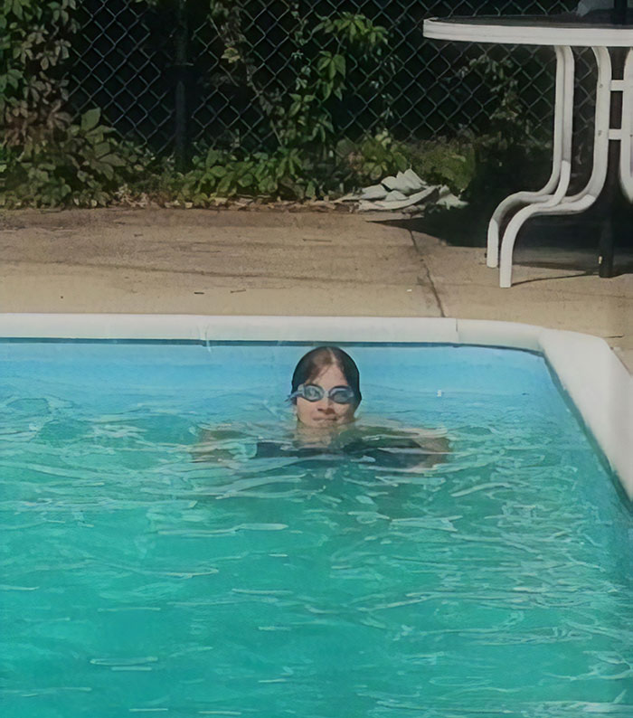 Woman with swimming googles swimming in a pool 