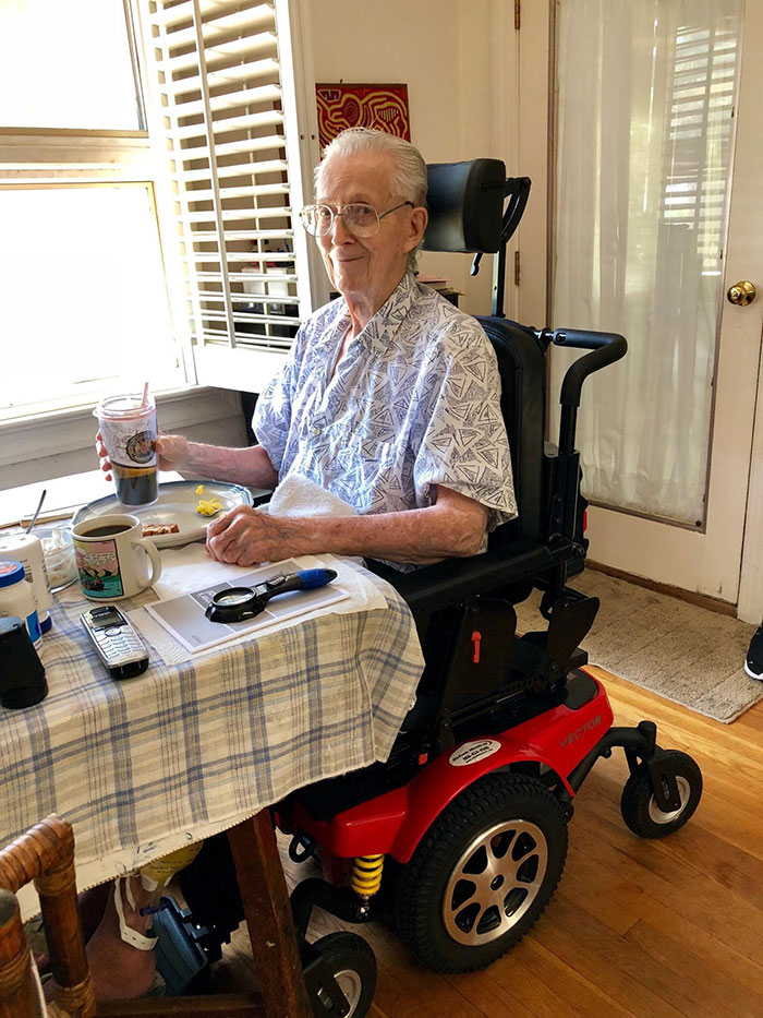 Man sitting in a wheelchair next to a table with food 