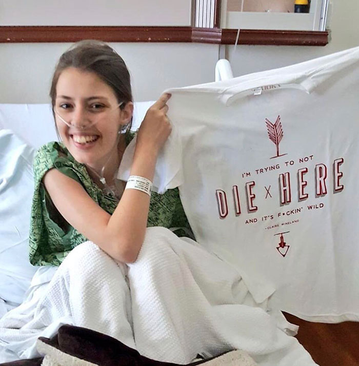 Woman in a hospital bed showing of her t-shirt 