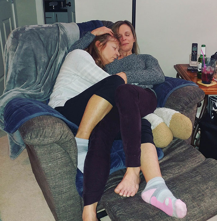 Mom and her mother laying and hugging each other on an armchair 