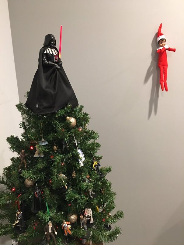 "Elf On The Shelf idea with the elf 'levitating' on the wall facing a Christmas tree topped with Darth Vader and decorated with Star Wars characters."