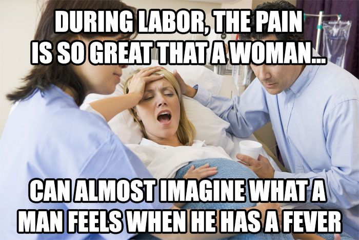 Doctors assisting a woman in labor, with a funny meme text about comparing labor pain to a man's fever.