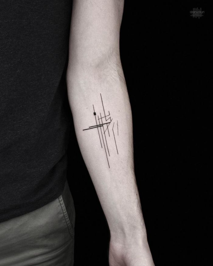 Geometric tattoo on forearm by Turkish artist, featuring intricate black lines and shapes.