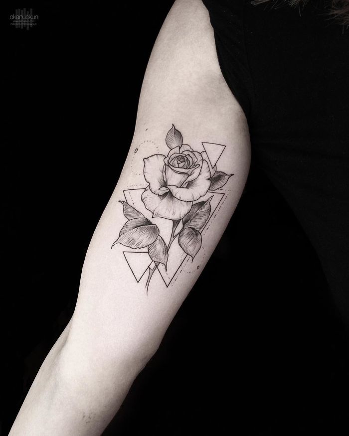 Geometric tattoo by Turkish artist Okan Uçkun featuring a rose with abstract shapes on an arm.