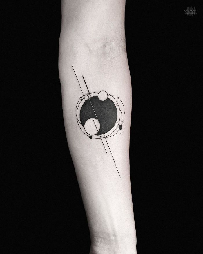 Geometric tattoo on forearm featuring circles and lines, designed by Turkish artist Okan Uçkun.