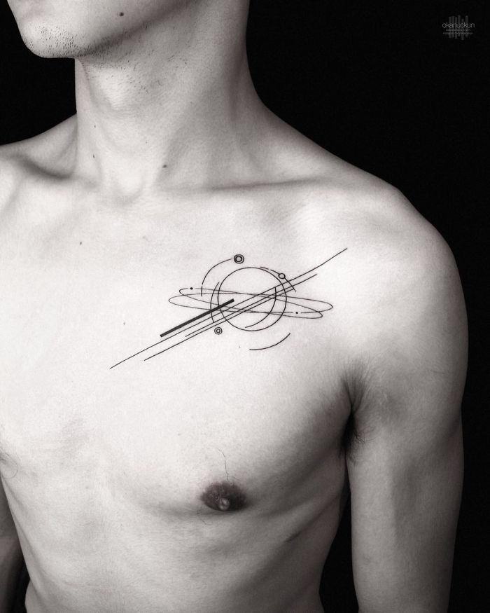 Geometric tattoo design by Turkish artist Okan Uçkun on a person's upper chest, featuring circles and lines.