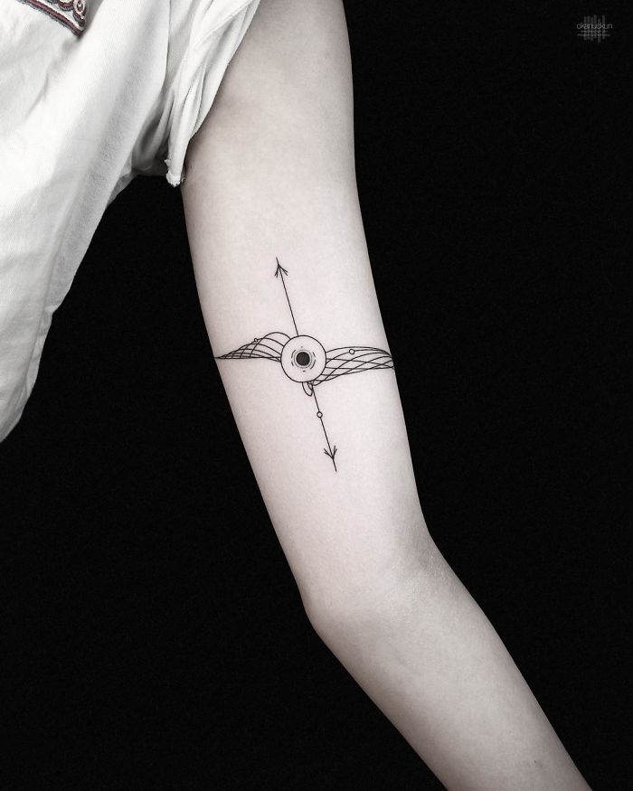 Geometric tattoo by Turkish artist Okan Uçkun, featuring intricate line design on a person's arm.