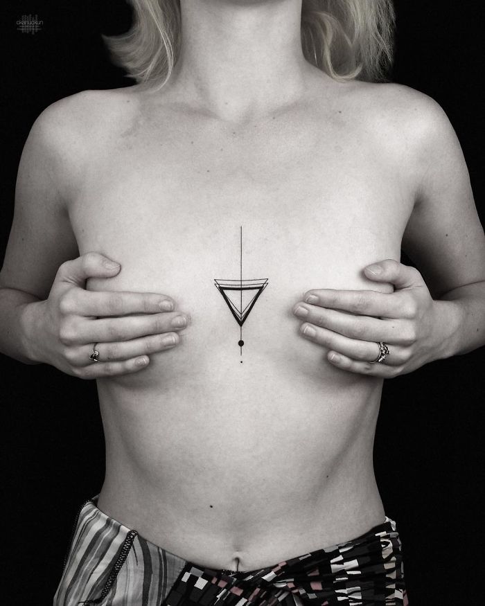 Person showcasing a geometric tattoo on their chest by Turkish artist.