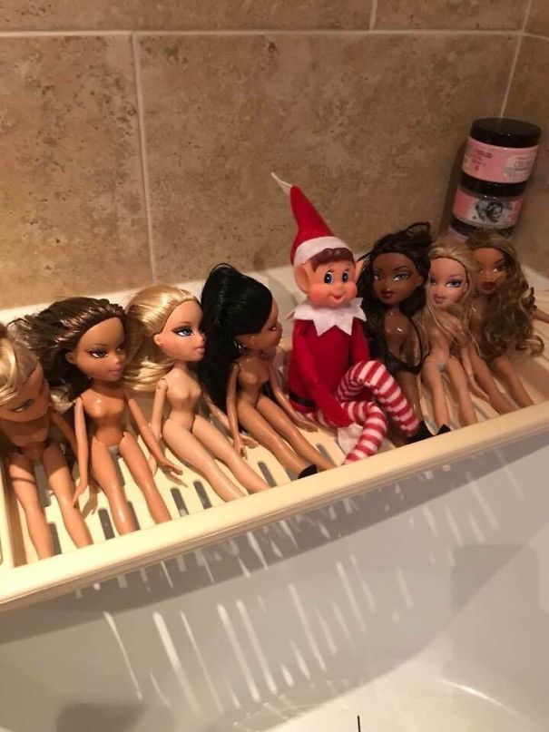 "Elf On The Shelf idea with the elf sitting in a bathtub tray surrounded by several fashion dolls, creating a playful bath scene."